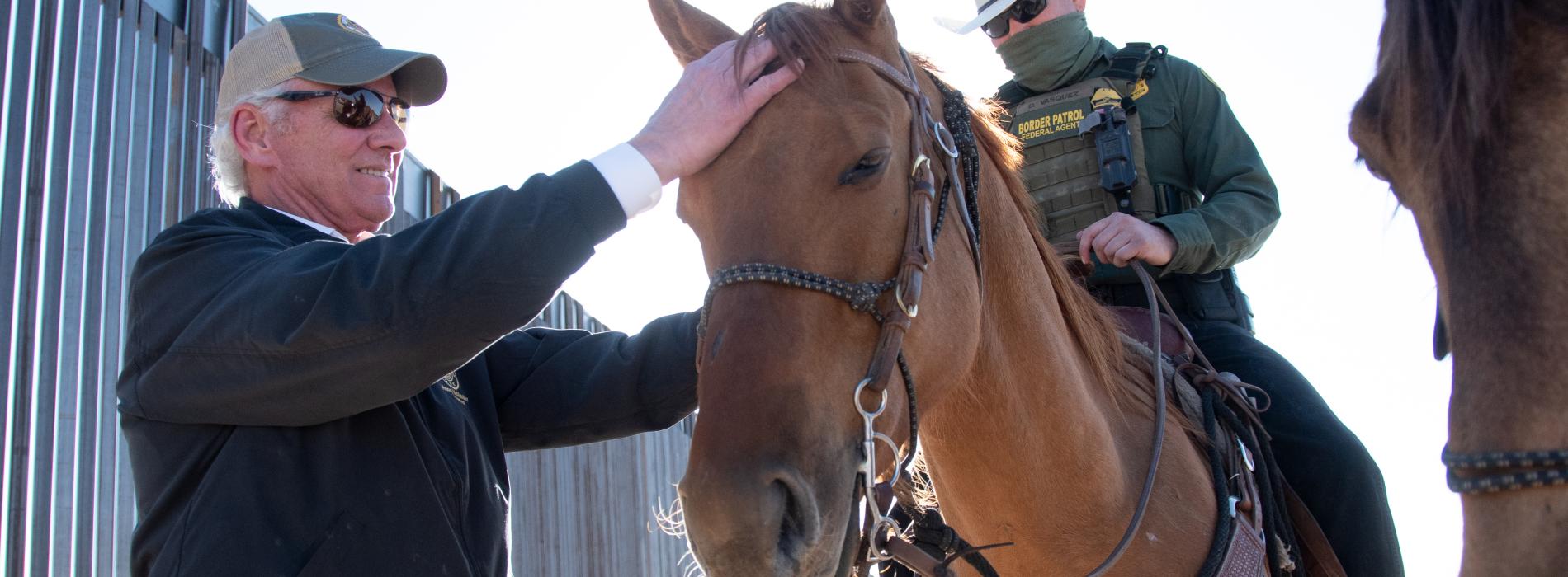Governor McMaster pets a horse with the U.S. Border Patrol. 